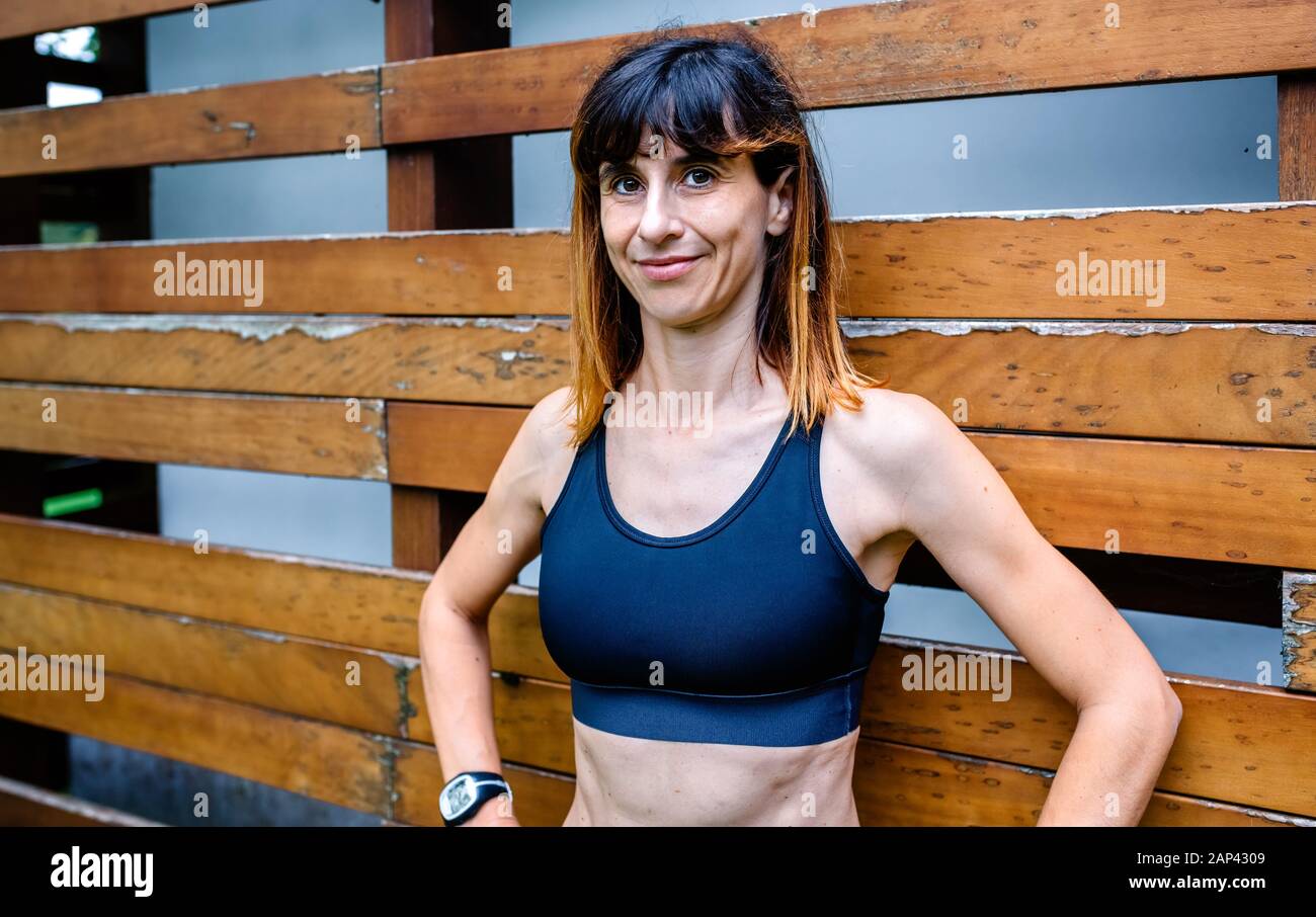 Une athlète féminine gaie devant un fond en bois Banque D'Images