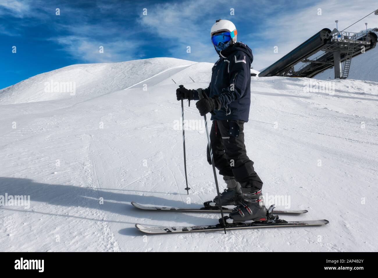 Jeune skieur sur une piste de ski avec casque et masque Banque D'Images