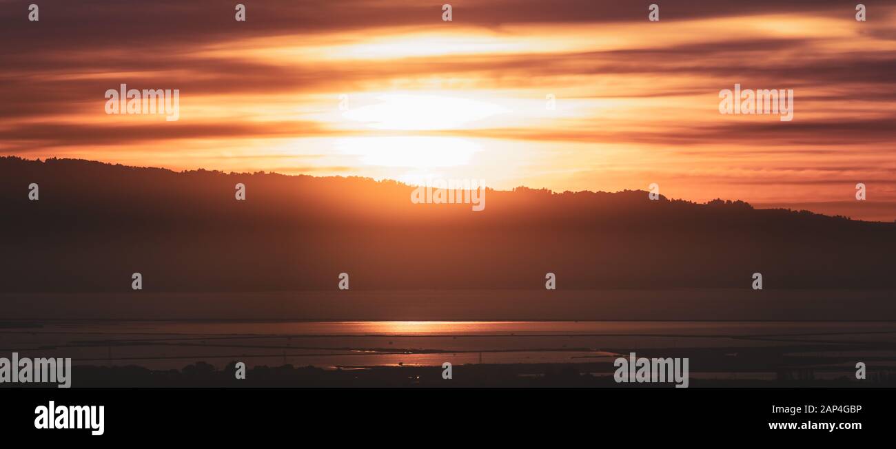 Soleil derrière les montagnes de Santa Cruz et se reflètent dans les eaux de la baie de San Francisco, Californie Banque D'Images
