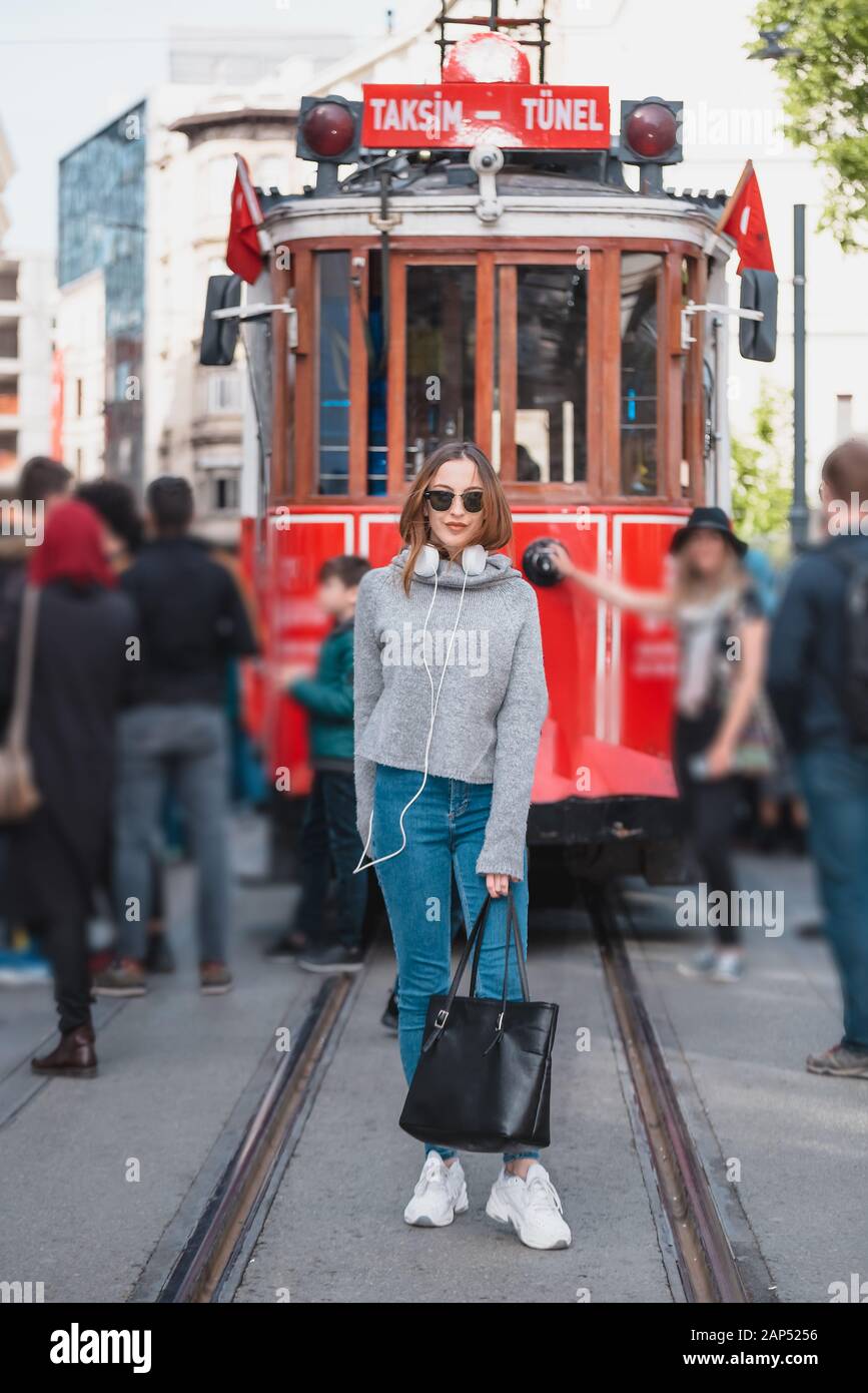 Belle jeune fille dans des vêtements à la mode pose devant le tram à la  populaire rue Istiklal à Istanbul, Turquie Photo Stock - Alamy