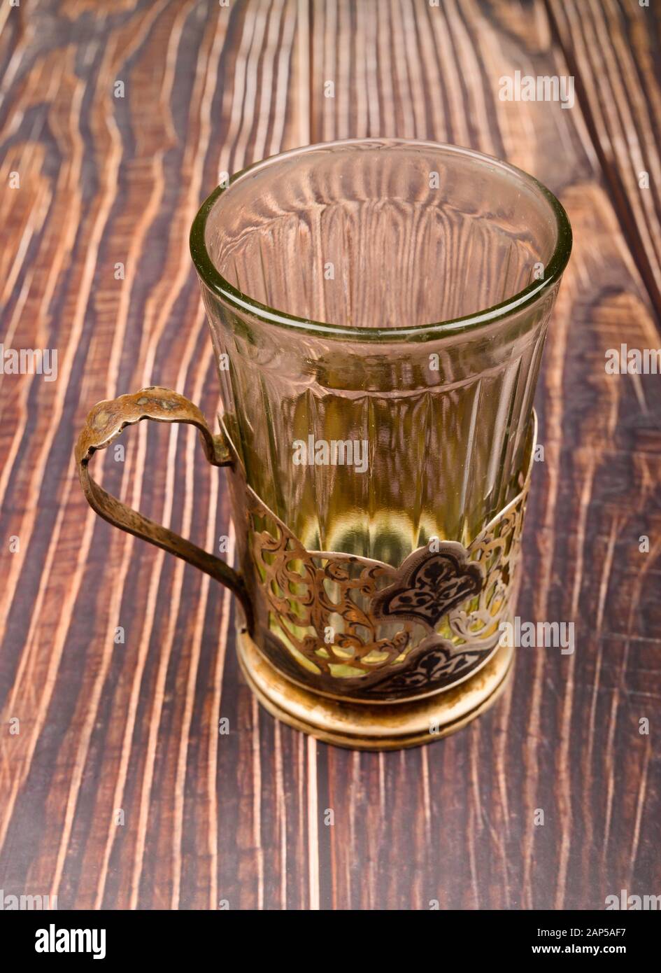 Verre dans un porte-gobelet en métal sur un fond en bois. Gros plan Banque D'Images