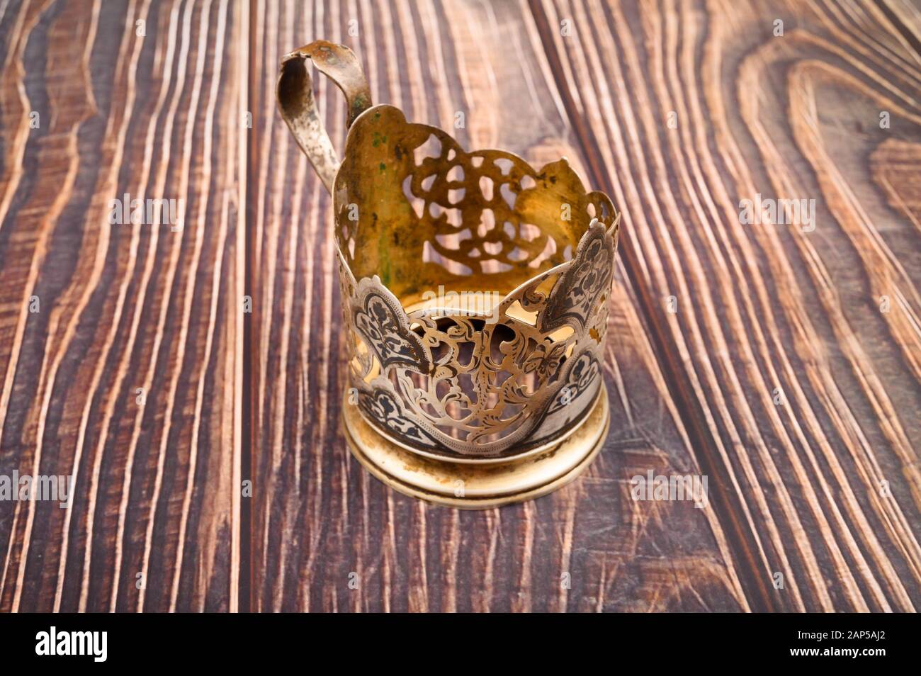 Verre dans un porte-gobelet en métal sur un fond en bois. Gros plan Banque D'Images