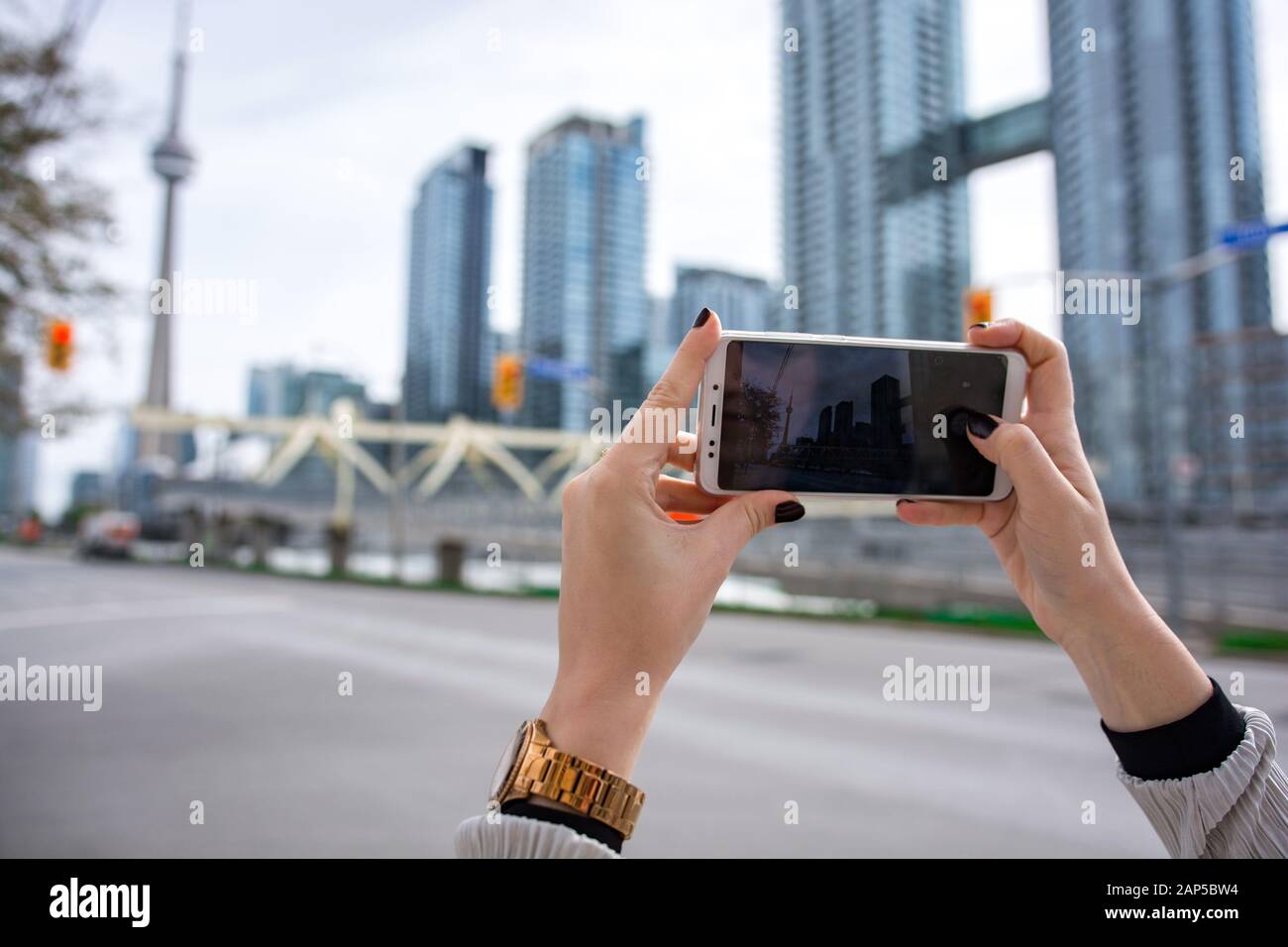 Fille prenant une photo de la Tour CN et du paysage urbain de Toronto avec téléphone mobile. Tenir le smartphone avec les mains Banque D'Images