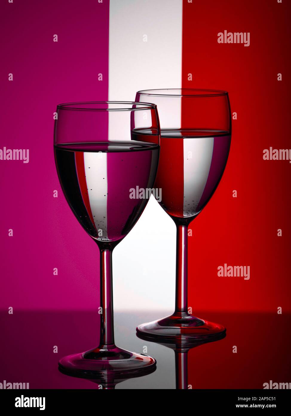 Verres à vin sur fond rouge et violet rayé Banque D'Images