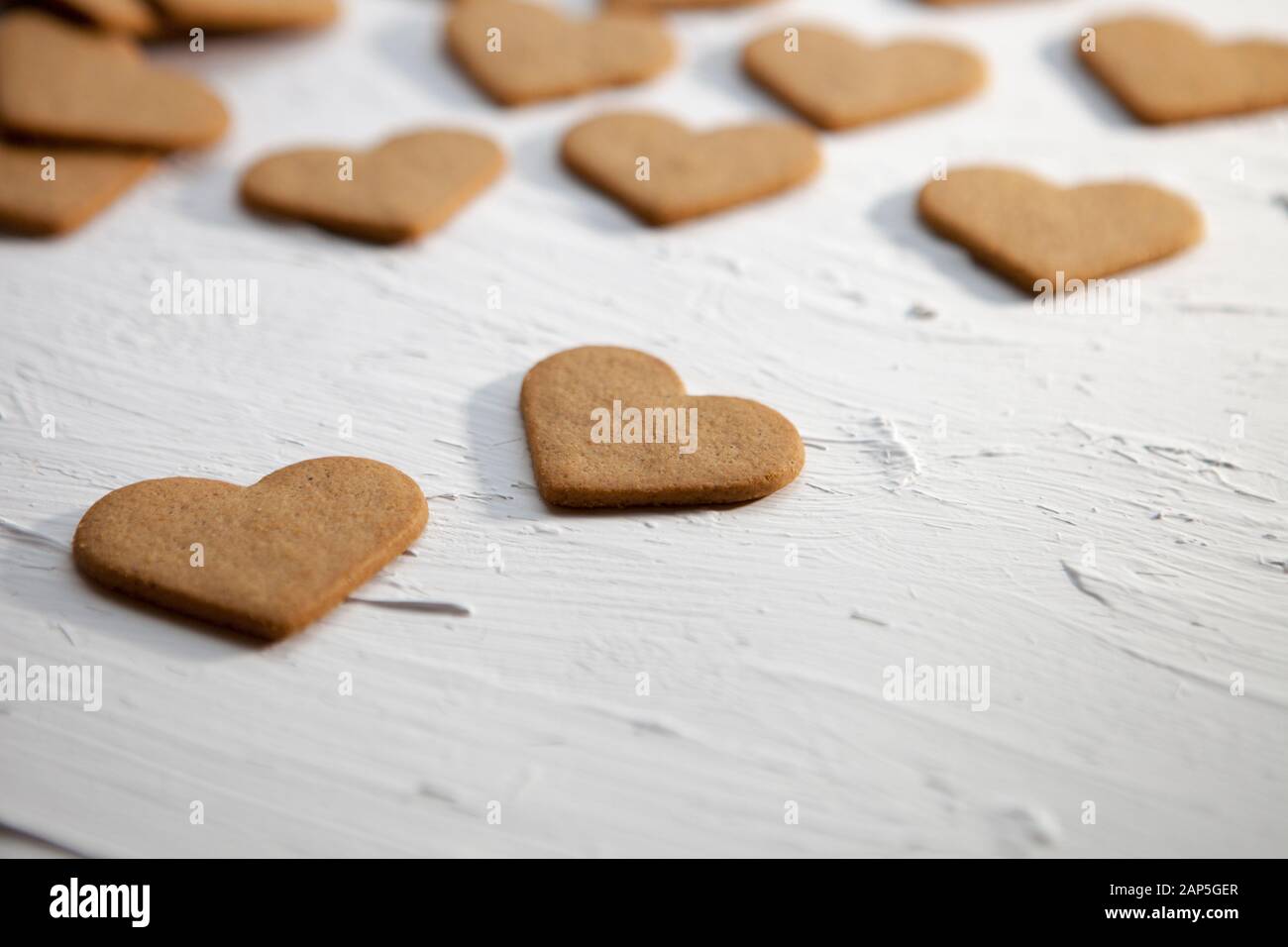 Coeurs délicieux cookies sur un fond blanc. Des biscuits sur un bâton en forme de cœur sur une table en bois. Les cookies avec des coeurs pour la Saint Valentin Banque D'Images