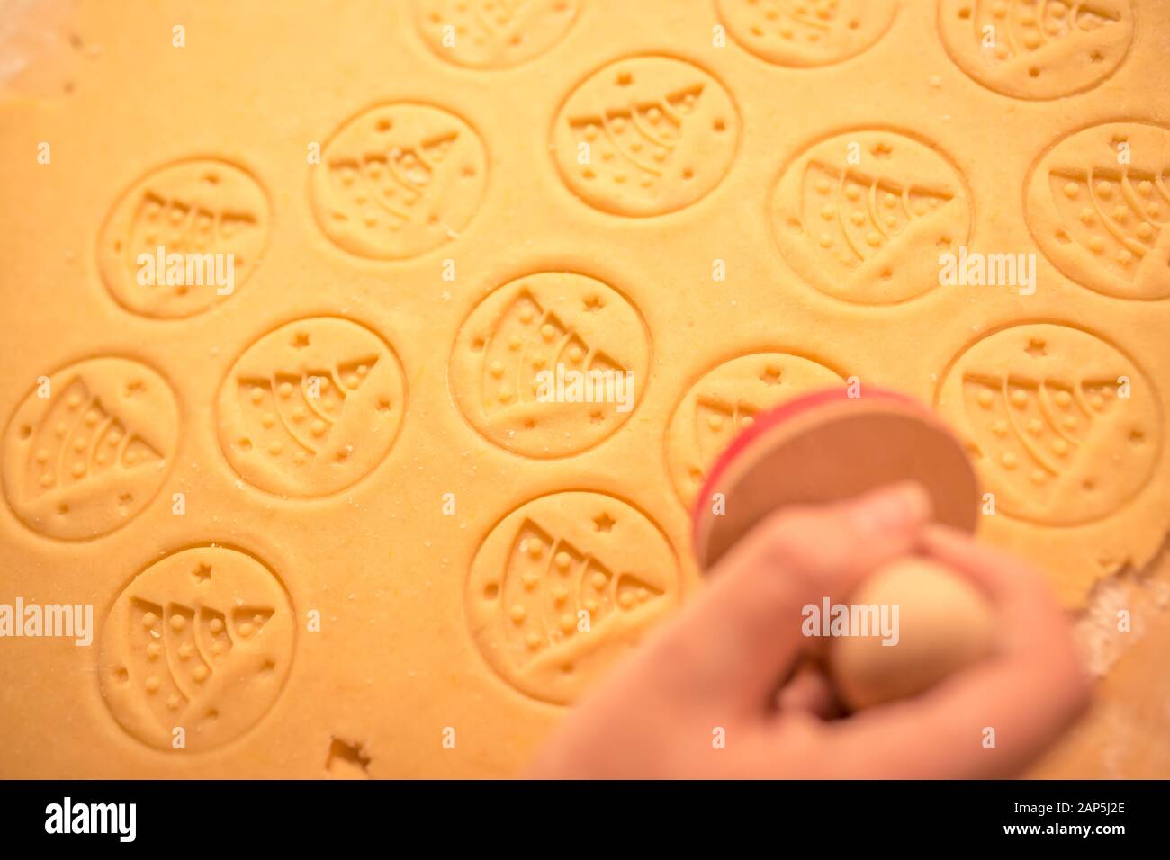 Pâte d'épices pour les biscuits de Noël et cookie stamp dans la main de femme. Timbre sur le thème de l'arbre de Noël, Noël nice texture de la pâte. Banque D'Images