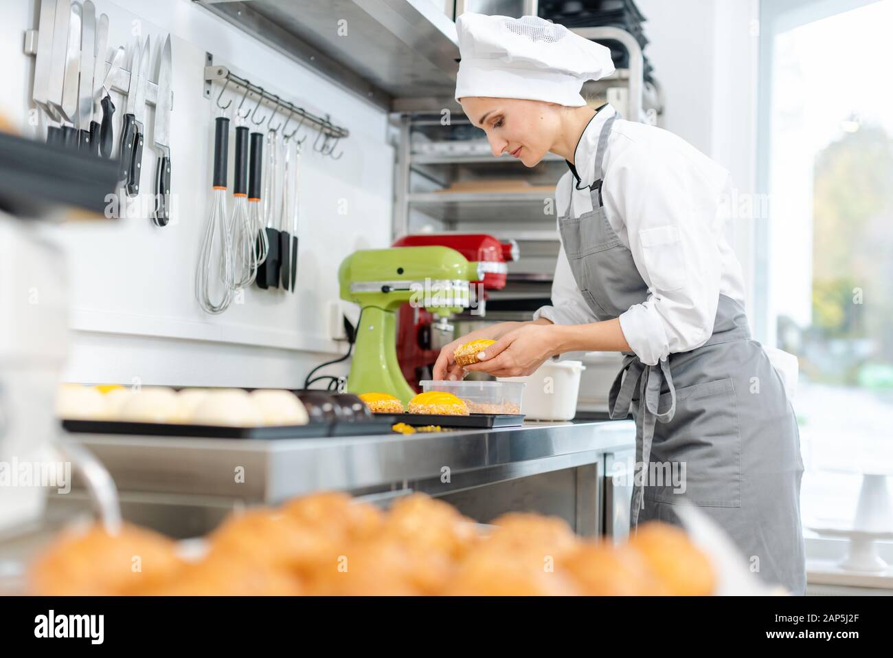 Confiseur travaillant sur petits gâteaux sucrés Banque D'Images