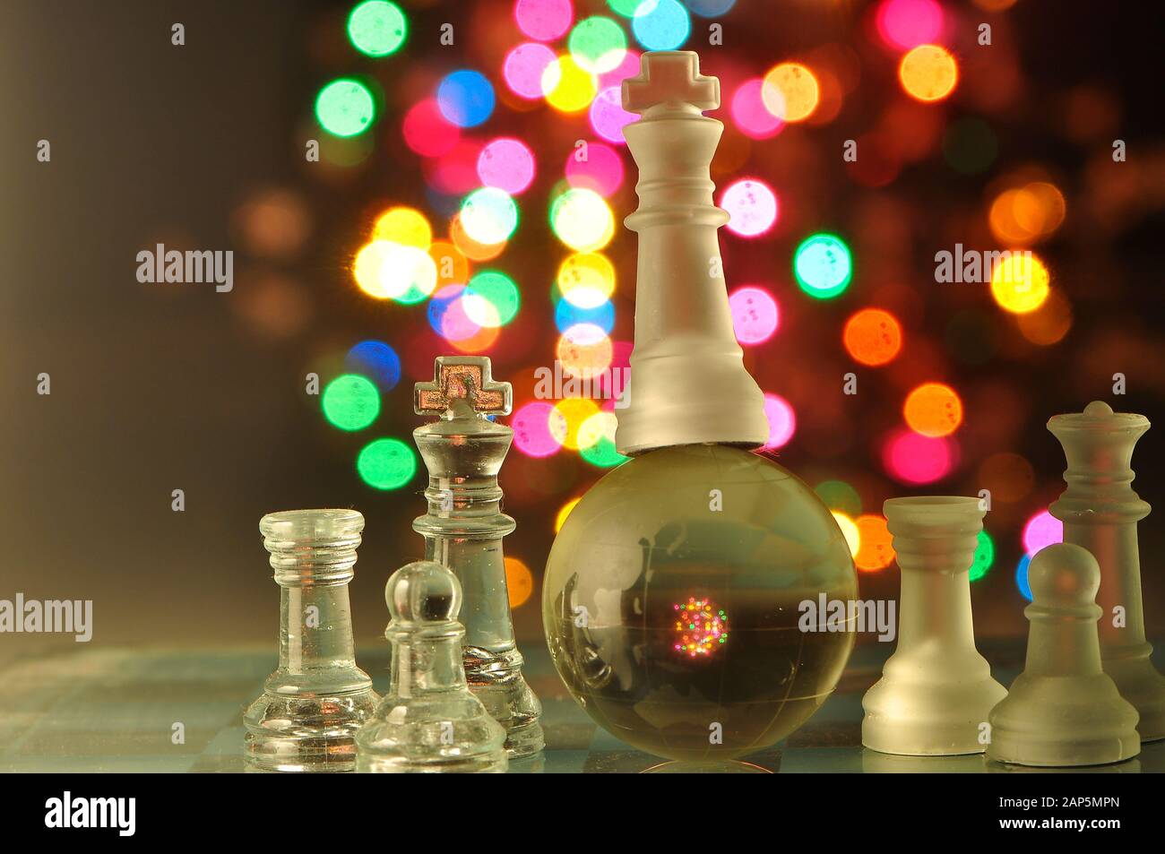Pièces de jeu d'échecs sur le chessboard, des spots colorés en arrière-plan Banque D'Images