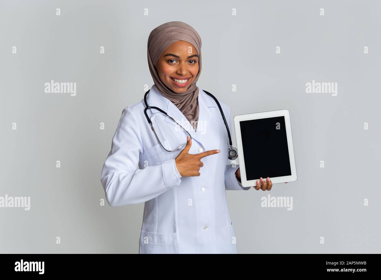 Afro musulman docteur femme pointant vers la tablette numérique avec l'espace noir Banque D'Images