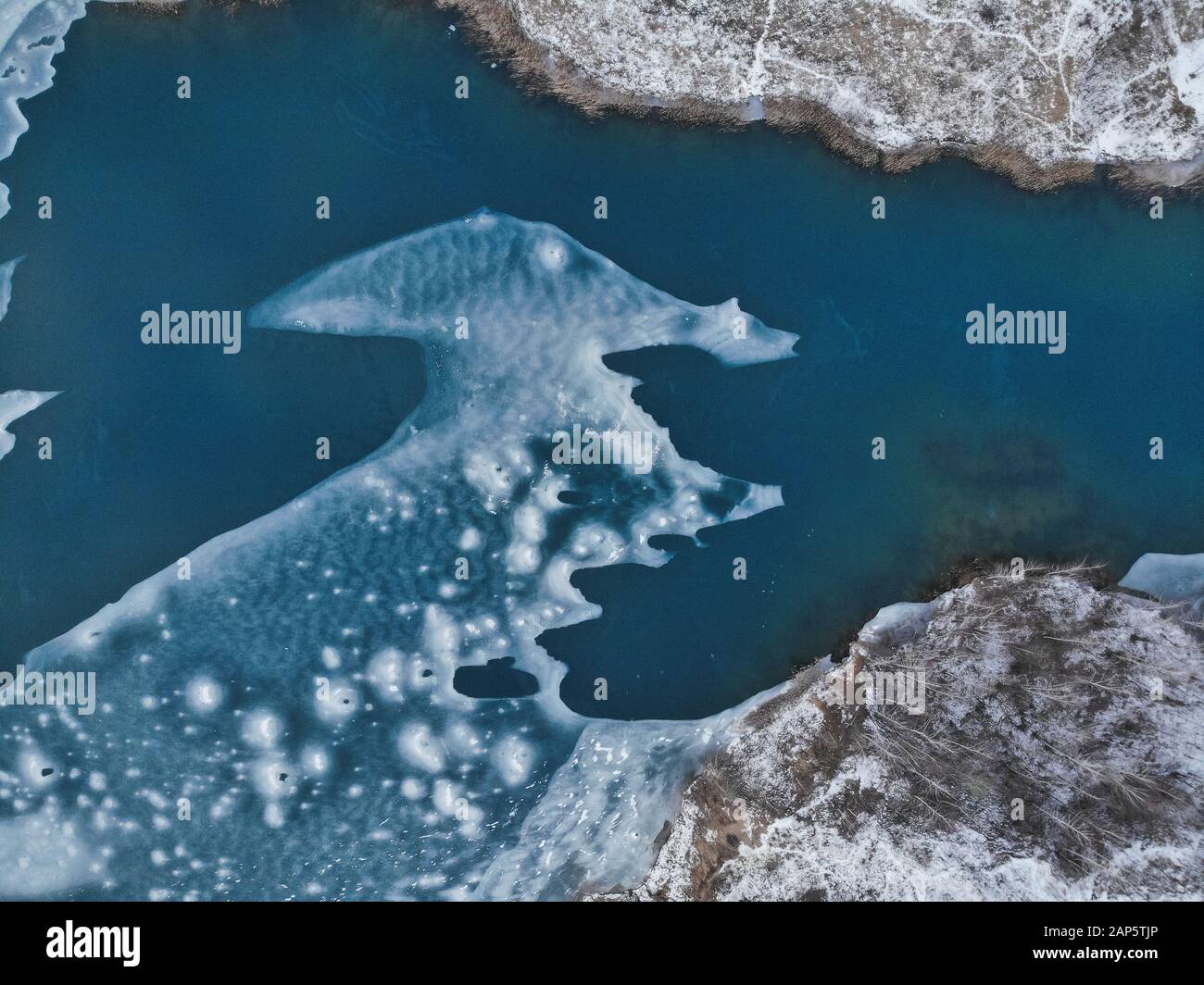 Vue aérienne des glaces. Vol au-dessus du lac gelé brisant la glace dans le lac rural. Photos de haute vue pendant la saison d'hiver. Banque D'Images