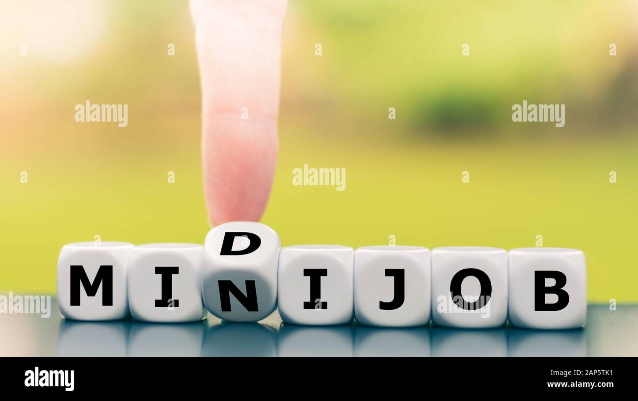 La main transforme un dé et change l'expression 'mini job' en 'idi job' (description de la relation de travail en Allemagne). Banque D'Images
