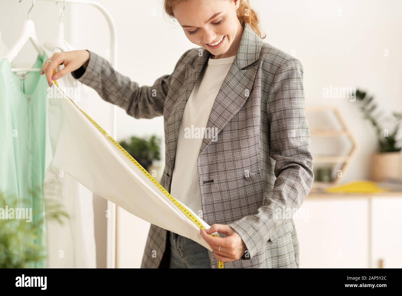 Design personnel. Couturier mesurant la longueur des manches dans l'atelier Banque D'Images