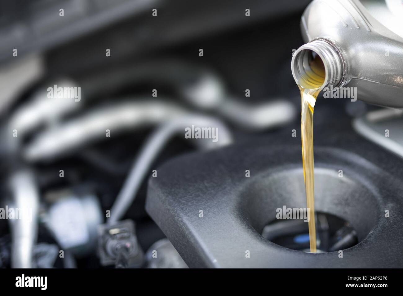 Versez de l'huile de moteur de voiture. L'huile fraîche versé au cours d'un changement d'huile d'une voiture. Banque D'Images
