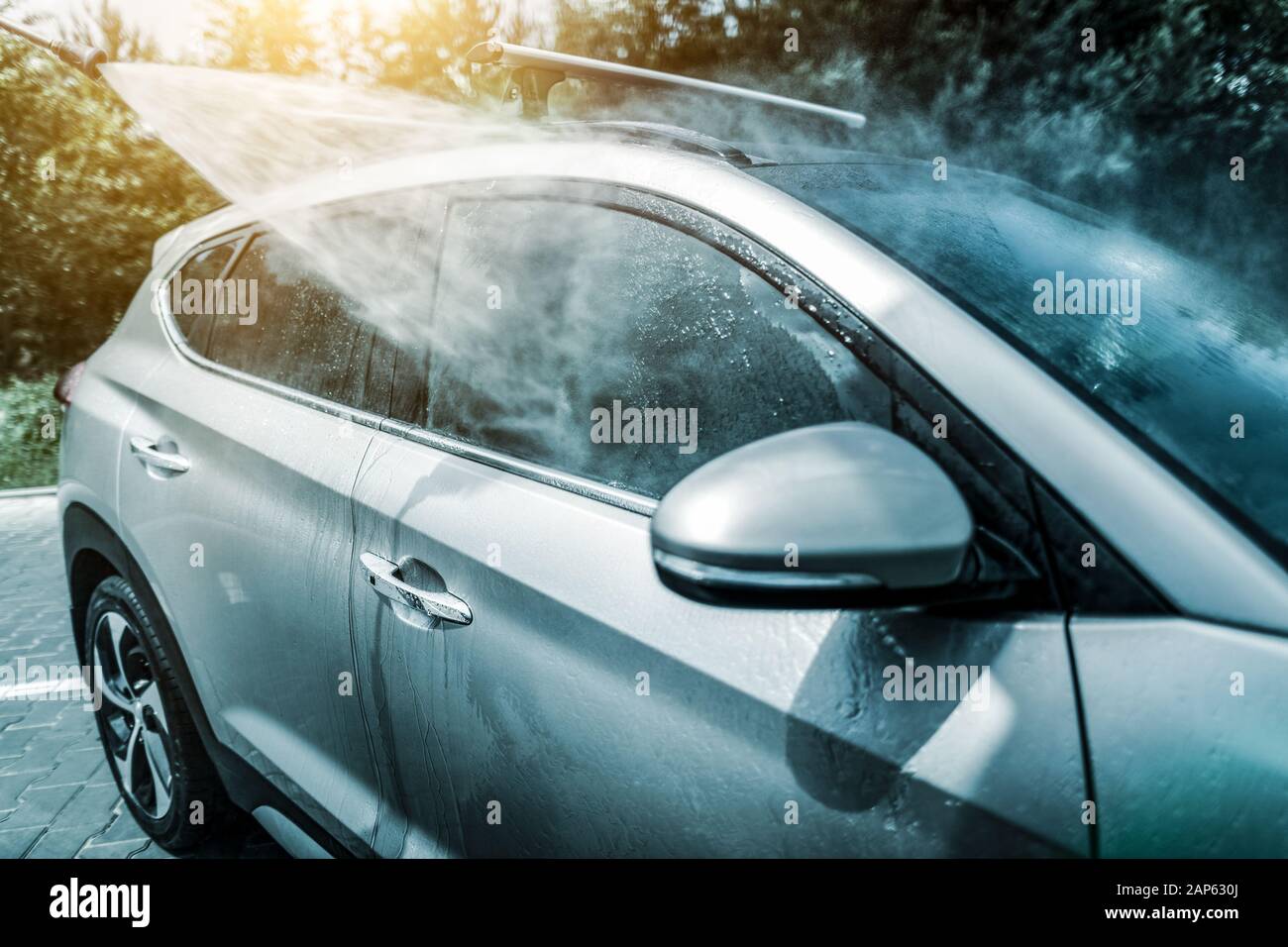 Lave-auto manuel avec de l'eau sous pression en lavage de voiture à l'extérieur. Banque D'Images