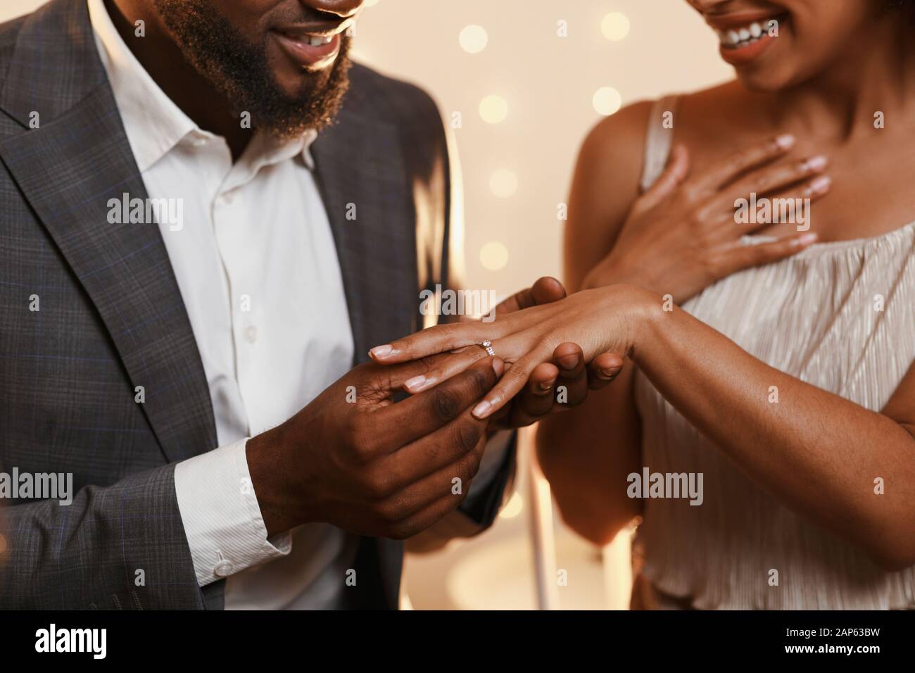 Homme noir mettant l'anneau sur son doigt de femme Photo Stock - Alamy