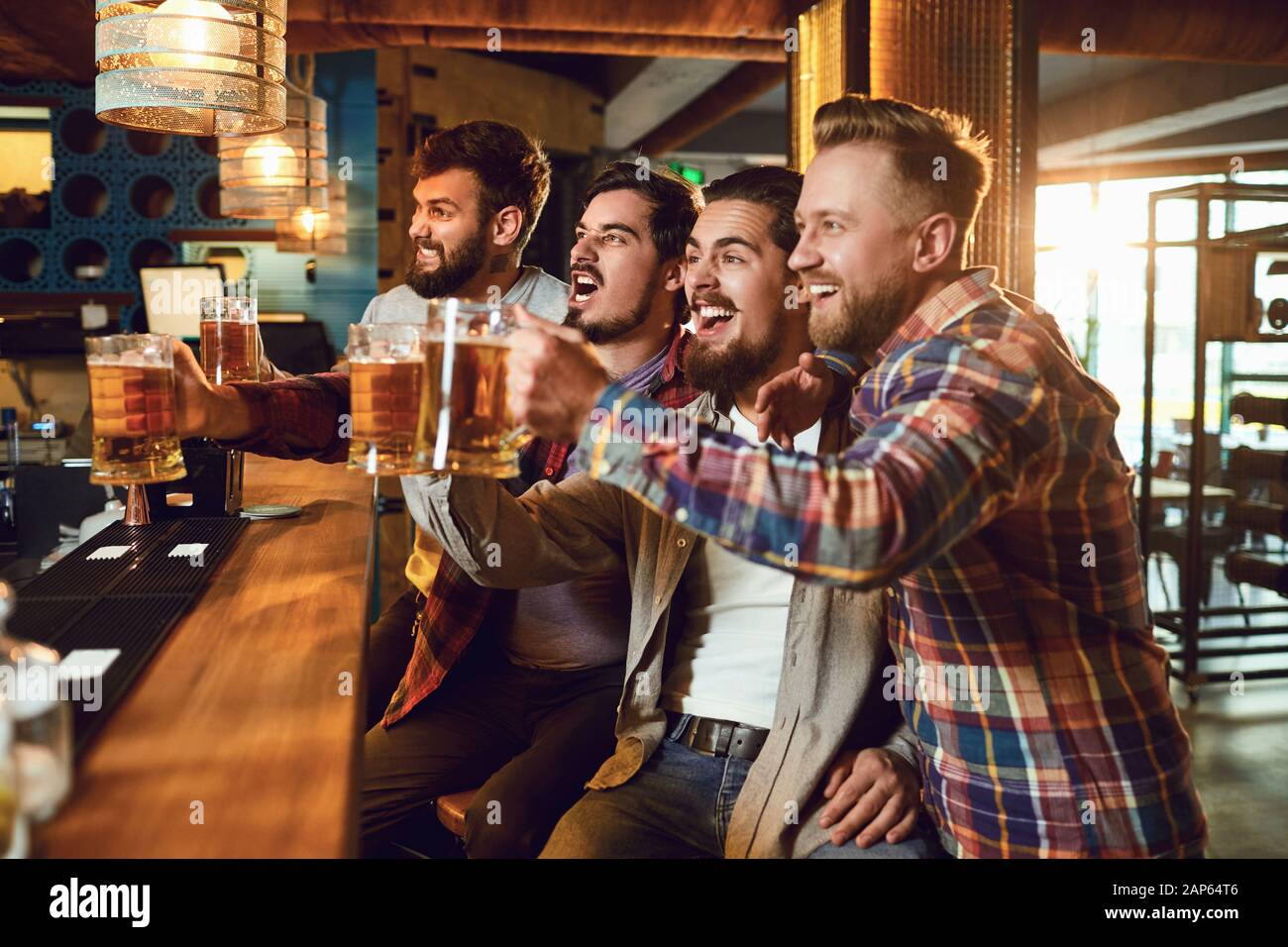 Un groupe de gars à regarder du sport à la télévision dans un pub et bar. Banque D'Images