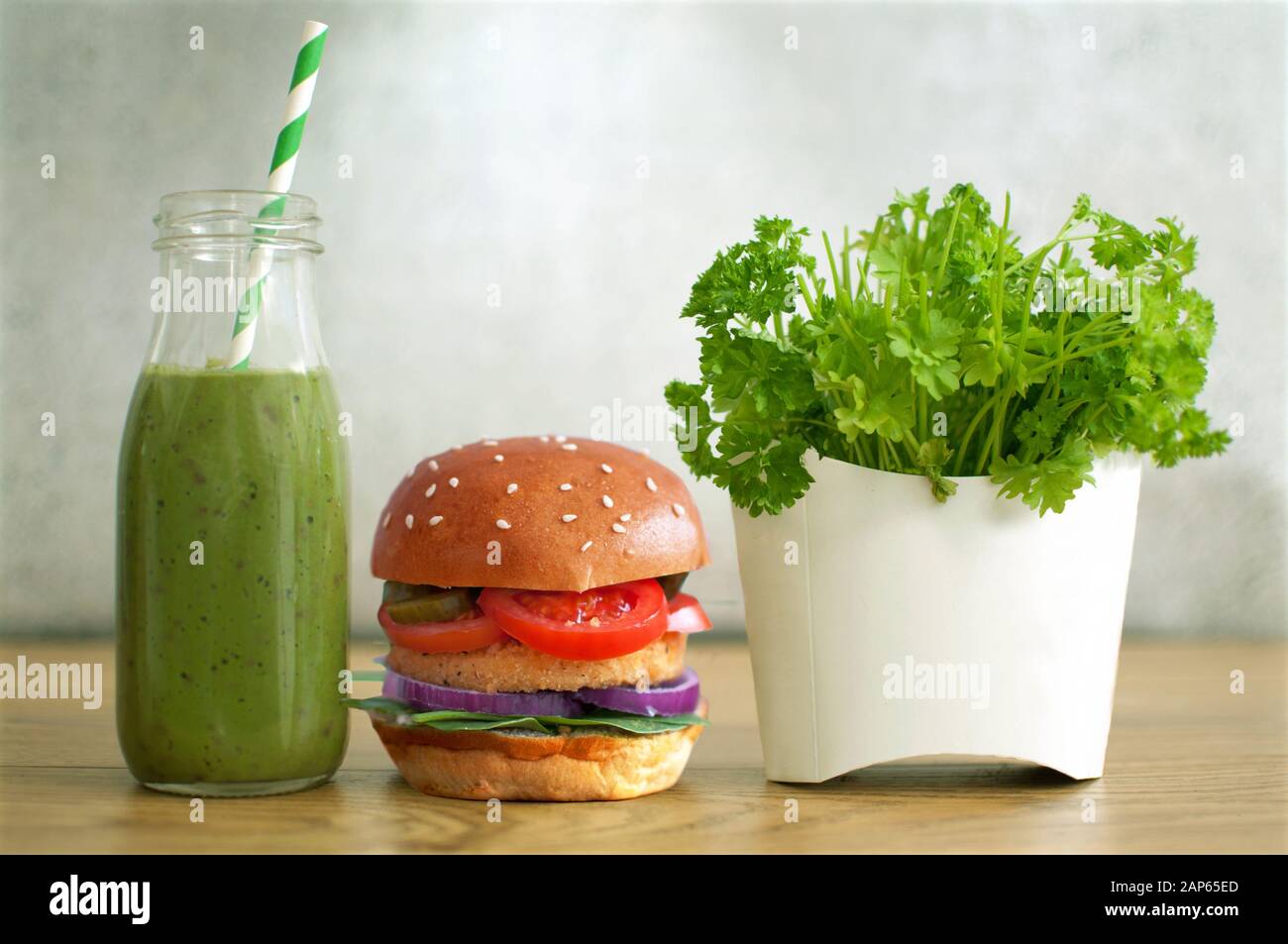 Des aliments sains et rapides, dont du hamburger, du smoothie aux légumes et de la salade dans un contenant de frites Banque D'Images