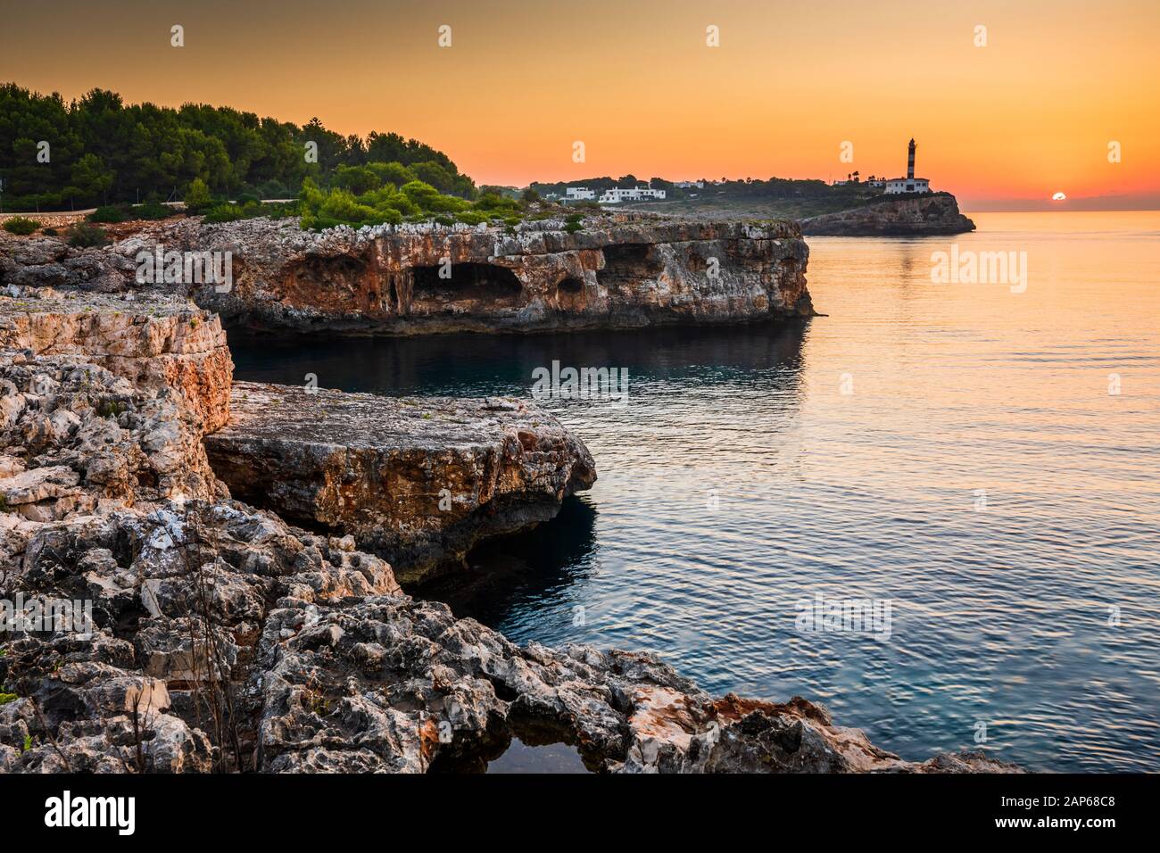 Lever du soleil avec rochers et phare de Porto colom, Majorque Banque D'Images