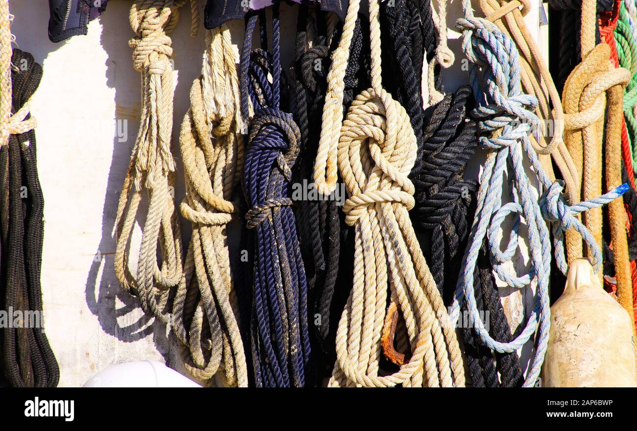 Vue sur des cordes de bateau isolées nouées accrochées sur le mur du navire dans une lumière naturelle et lumineuse Banque D'Images