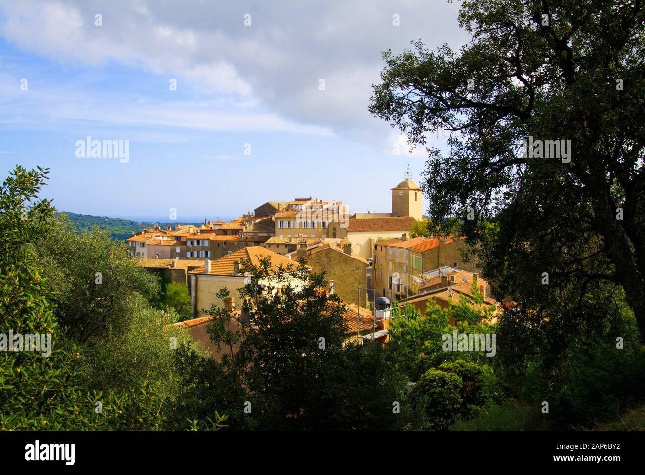 Vue panoramique au-delà des arbres sur le village médiéval méditerranéen français avec tour d'église sur le sommet de la colline - Ramatuelle, Côte d'Azur, France Banque D'Images