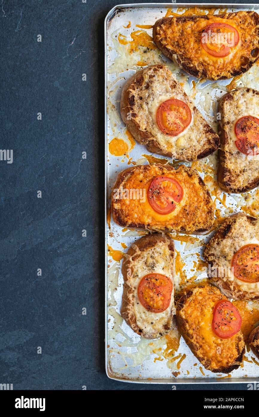 Fromage sur pain grillé. Tomate et fromage sur du pain au levain grillé sur une plaque de cuisson Banque D'Images