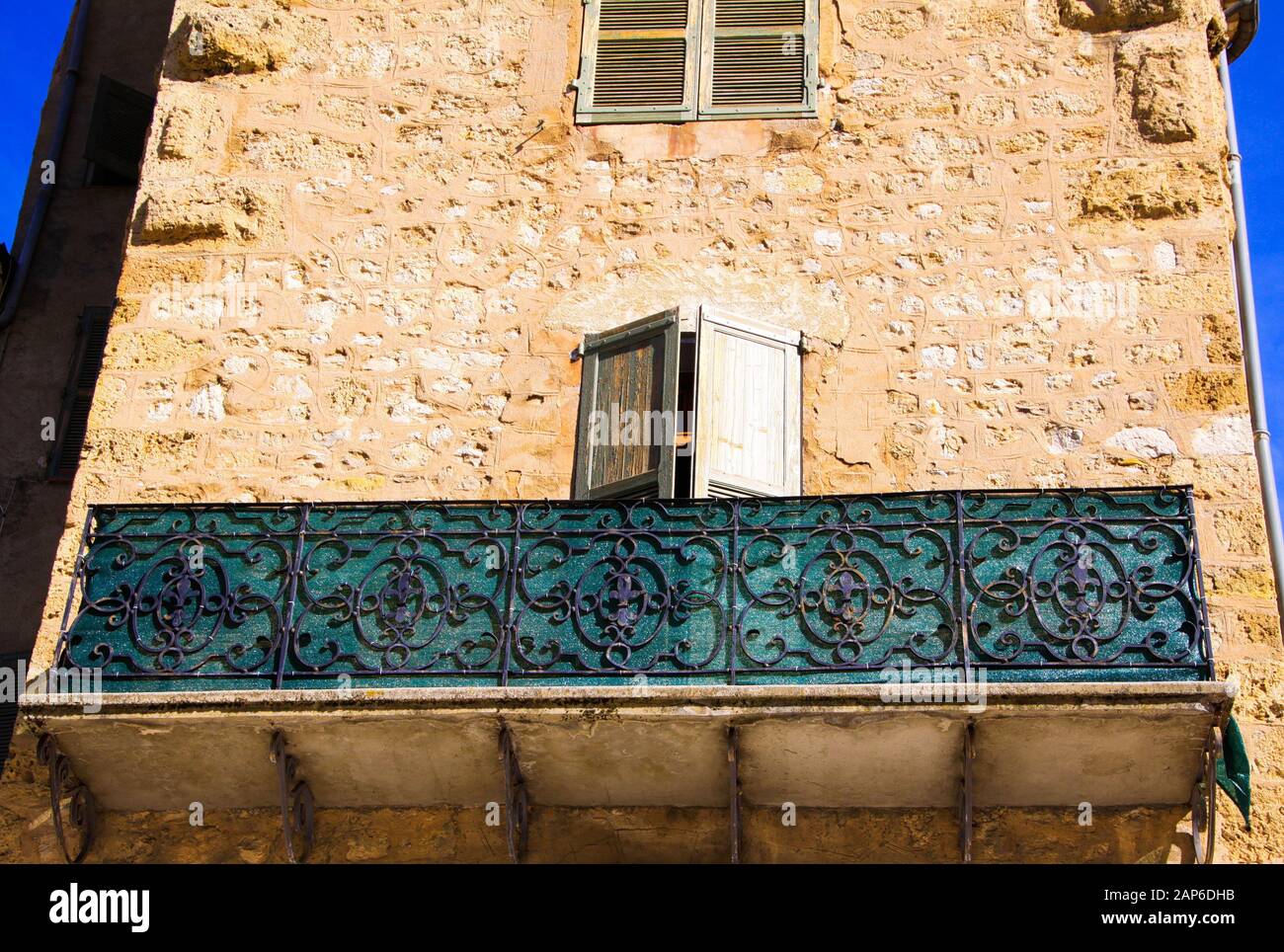 Vue à bas angle sur la façade en pierre de la maison française typique et balcon avec travaux de treillis ornementé - Castellane, France Banque D'Images