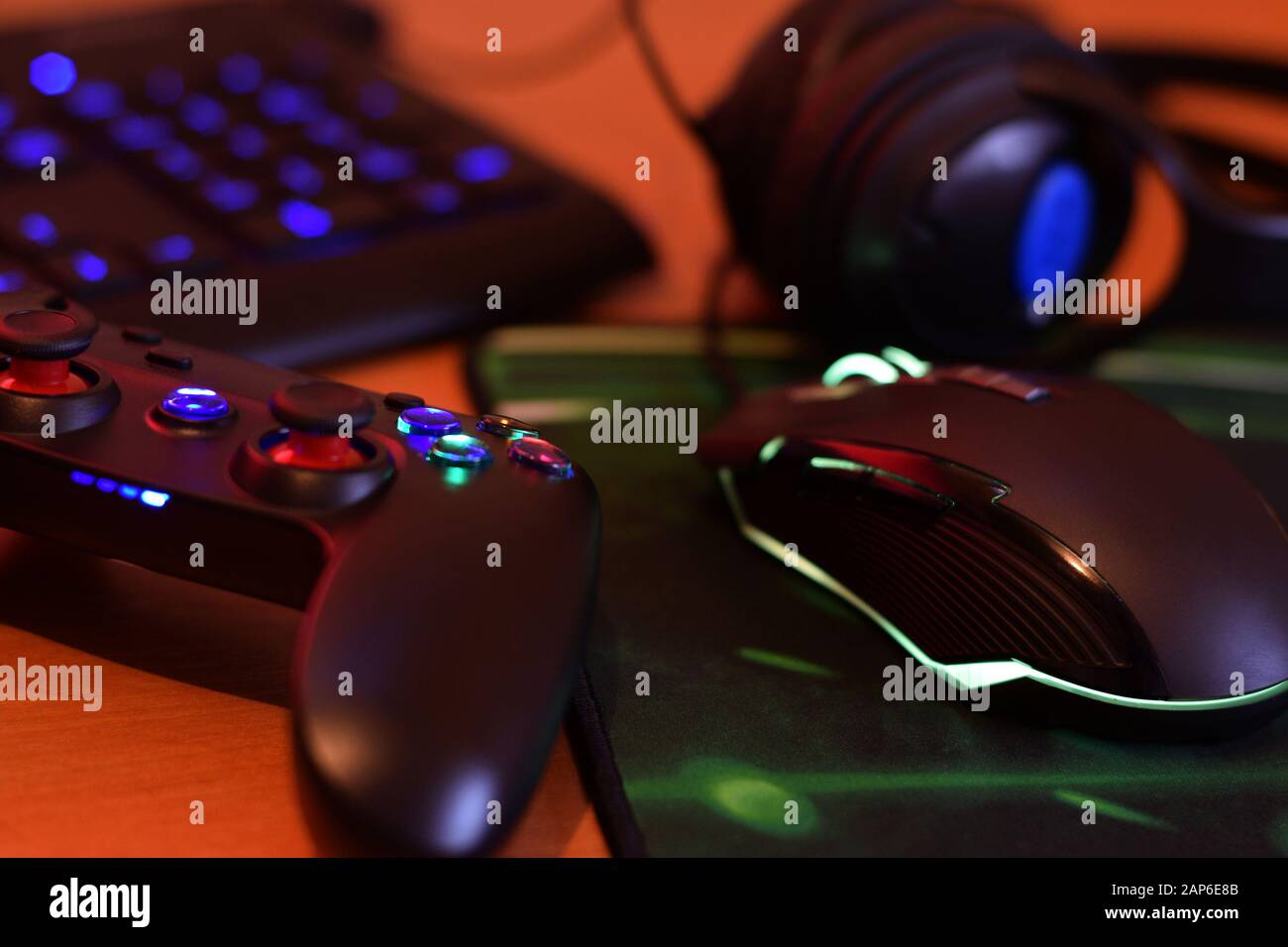 La manette de jeu et la souris de jeu modernes sont équipées d'un clavier et d'un casque sur la table dans une salle de jeux sombre. Concept de jeu d'équipe coopératif Banque D'Images