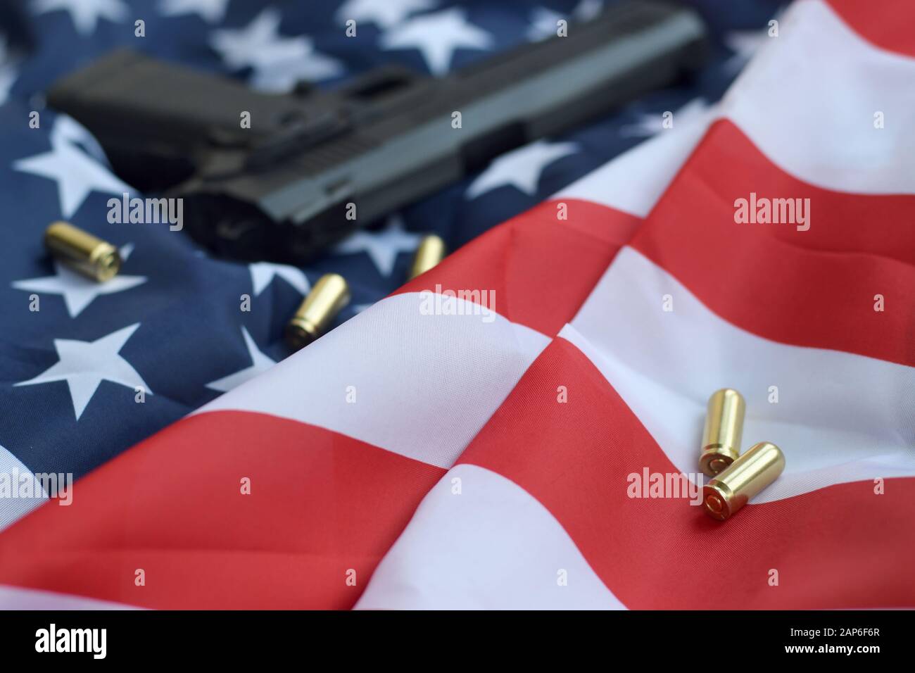 Balles de 9 mm et pistolet se trouvent sur le drapeau américain plié. Un ensemble d'éléments de protection automatique ou de kit d'entretien spécial Banque D'Images