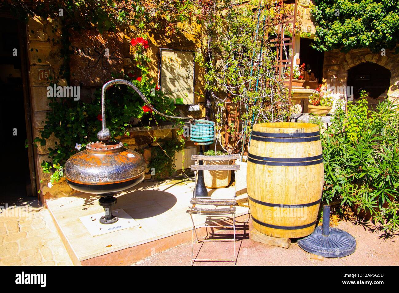 Roussillon En Provence, France - 2 Octobre. 2019: Vue sur la maison méditerranéenne d'ocre rouge avec la vigne grimpant la façade, tonneau de vin, chaise pliant en bois Banque D'Images