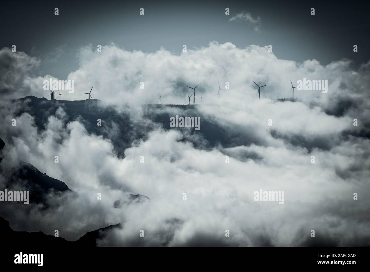 Centrale éolienne installée sur le sommet de la montagne avec des nuages spectaculaires Banque D'Images