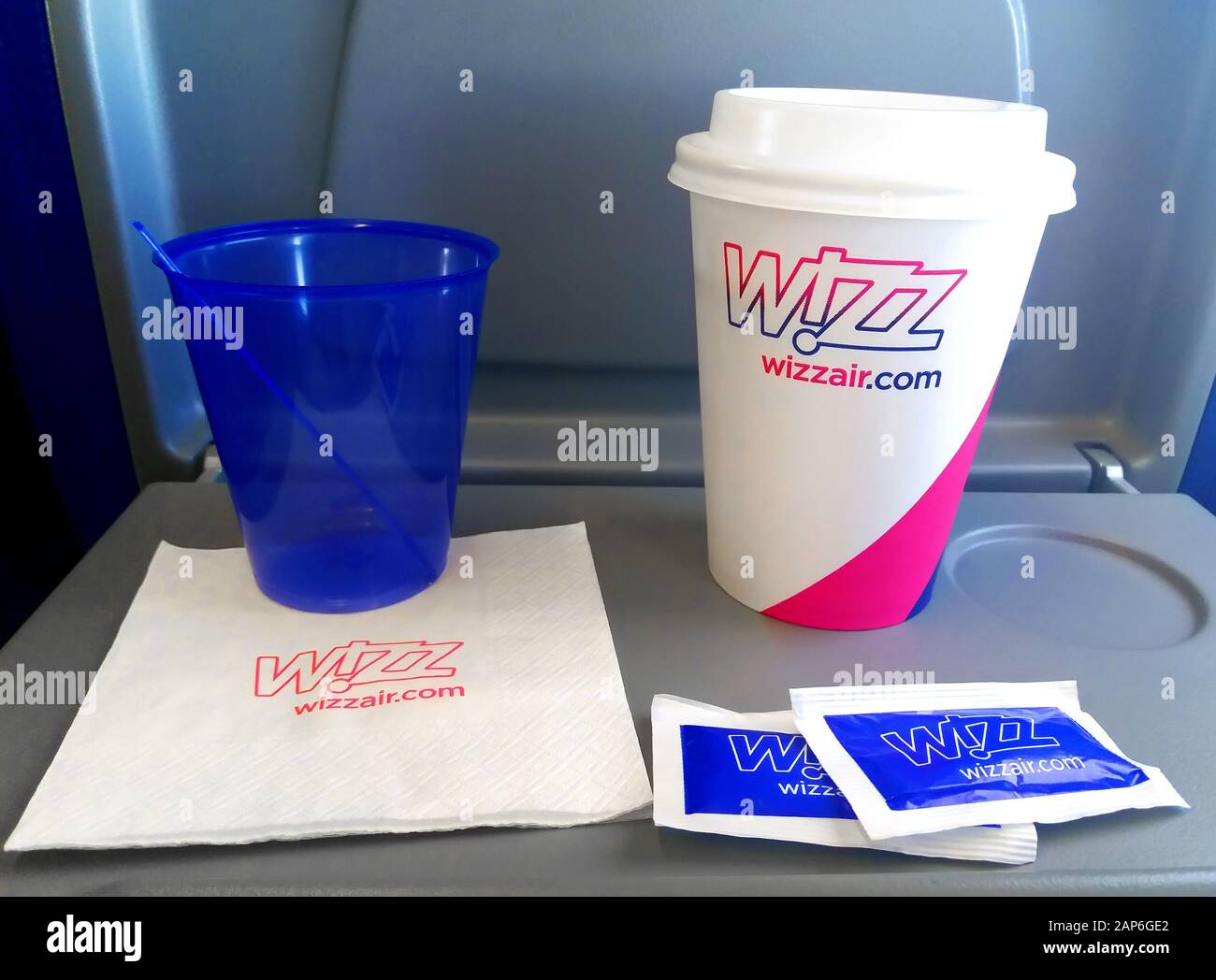 Kiev, UKRAINE - 30 AOÛT 2019: Ensemble Wizz Air composé de deux tasses en plastique, serviette et sucre marqués de logos Banque D'Images