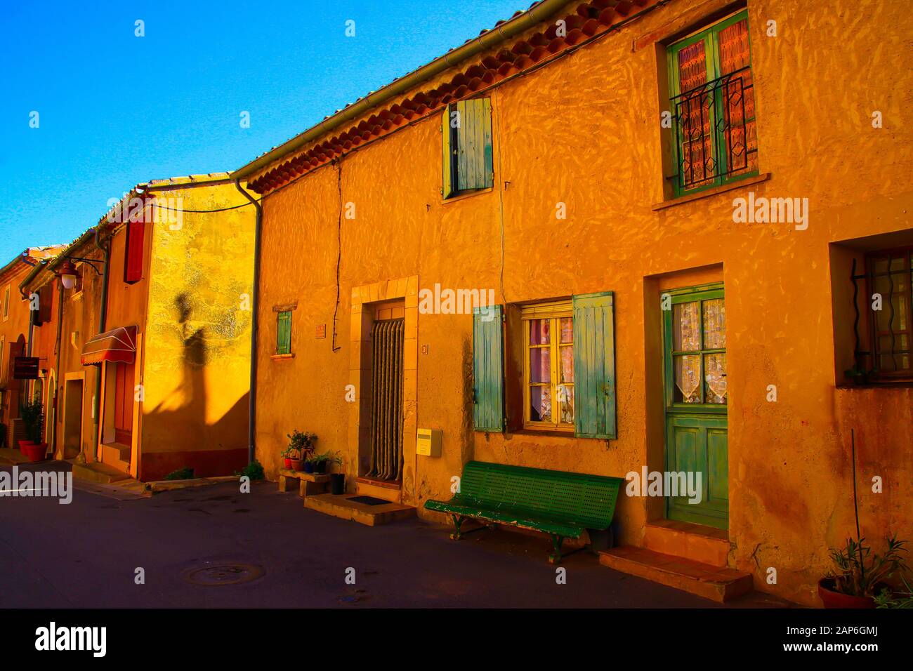 Roussillon En Provence, France - 2 Octobre. 2019: Vue sur la façade des maisons jaunes rouges typiques contre le ciel bleu Banque D'Images