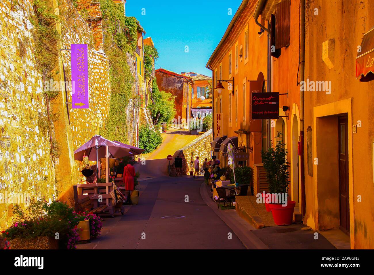Roussillon En Provence, France - 2 Octobre. 2019: Vue sur la rue avec mur de pierre naturel de forteresse et maisons jaunes ocre françaises agai Banque D'Images