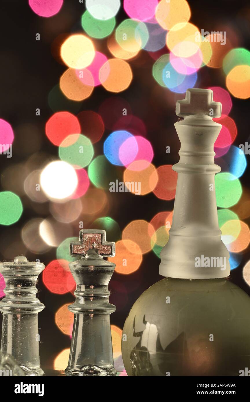 Pièces de jeu d'échecs sur le chessboard, des spots colorés en arrière-plan Banque D'Images