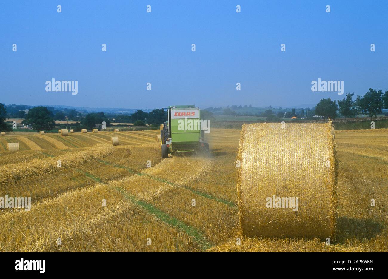 Des agriculteurs des balles de paille dans un champ de la paille d'orge. UK. Banque D'Images