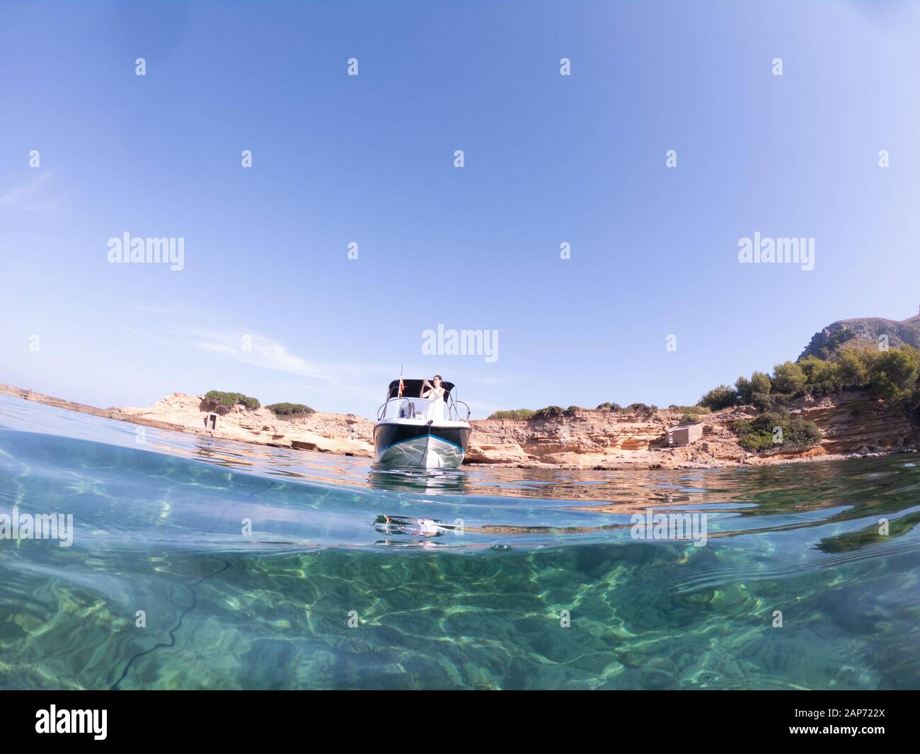 Une fille sur un petit bateau à moteur prend la photo, Espagne, Majorque Banque D'Images