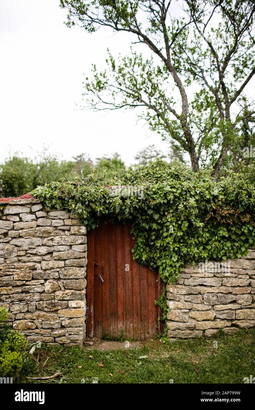 Porte en bois rouge sur le mur en pierre dans la campagne française Banque D'Images