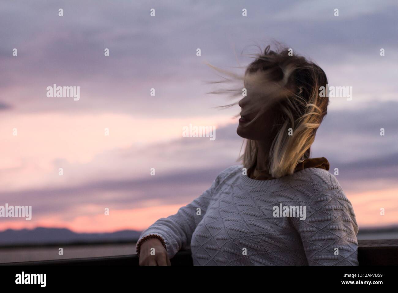 Les femmes qui regardent loin le vent lui souffle les cheveux Banque D'Images
