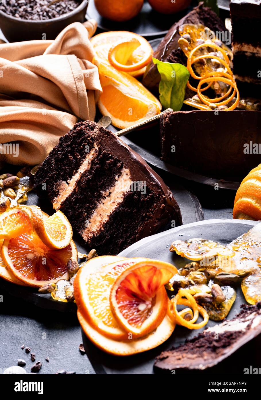 Une épopée Gâteau au chocolat sans gluten à base de ricotta, de chocolat de remplissage, glaçage glaçage au chocolat, des tranches d'orange et praliné pistache servi avec c Banque D'Images