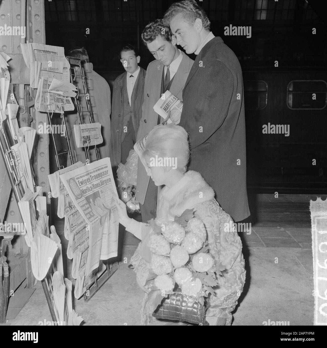 Arrivée danseuse Marika Kilius et Hans Jürgen Bäumler à la gare centrale d'Amsterdam, Marika Kilius voit un journal allemand, debout Hans Jurgen et Werner Zahn Annotation: Ils se sont produits à la revue de glace viennese Date: 7 octobre 1964 lieu: Amsterdam, Noord-Holland mots clés: Arrivées Nom personnel: Bäumler, Hans-Jürgen, Kilika, Marius Banque D'Images