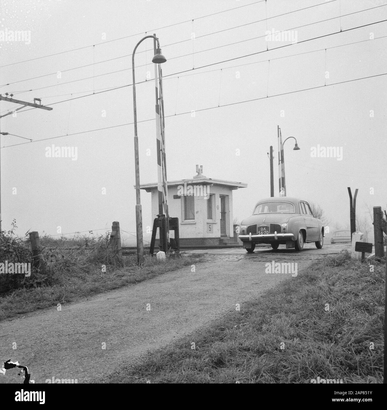 Volkswagen van qui est entré en collision avec un train à un passage de chemin de fer à Leidschendam Description: Voiture passant par le passage de chemin de fer à Leidschendam Date: 11 novembre 1965 lieu: Leidschendam, Zuid-Holland mots clés: Voitures, passages à niveau, sécurité routière Banque D'Images