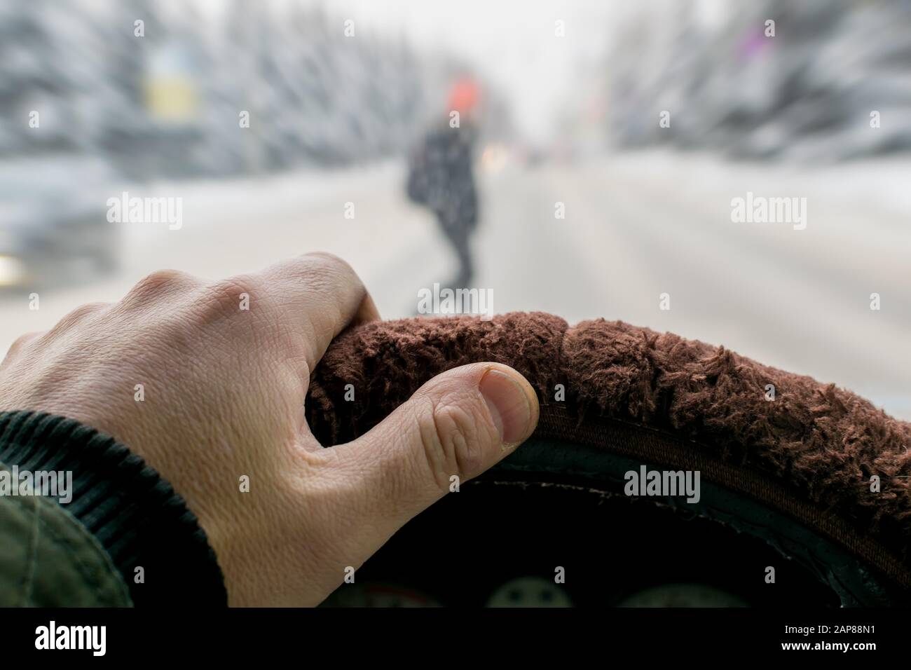 Urgence. Une main d'homme sur le volant d'une voiture tout en freinant sur le fond d'un piéton qui apparaît soudainement Banque D'Images