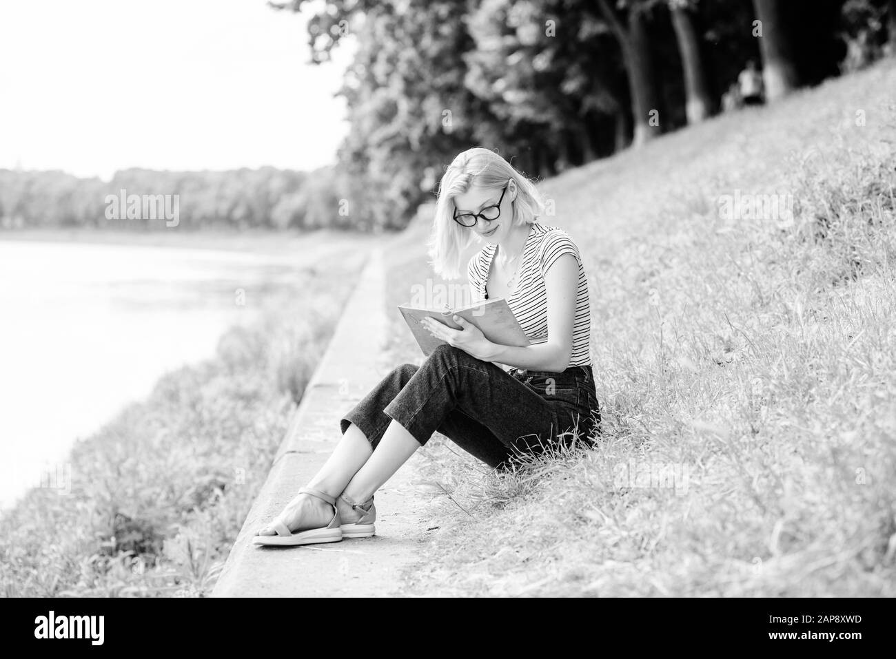 Roman inspiré par l'auteur. histoire intéressante. Vous pourrez vous détendre et faire de nouvelles informations. La lecture est mon passe-temps. Étude de l'été. femme en park reading book. student girl with book. scolaire pour prendre des notes. Banque D'Images