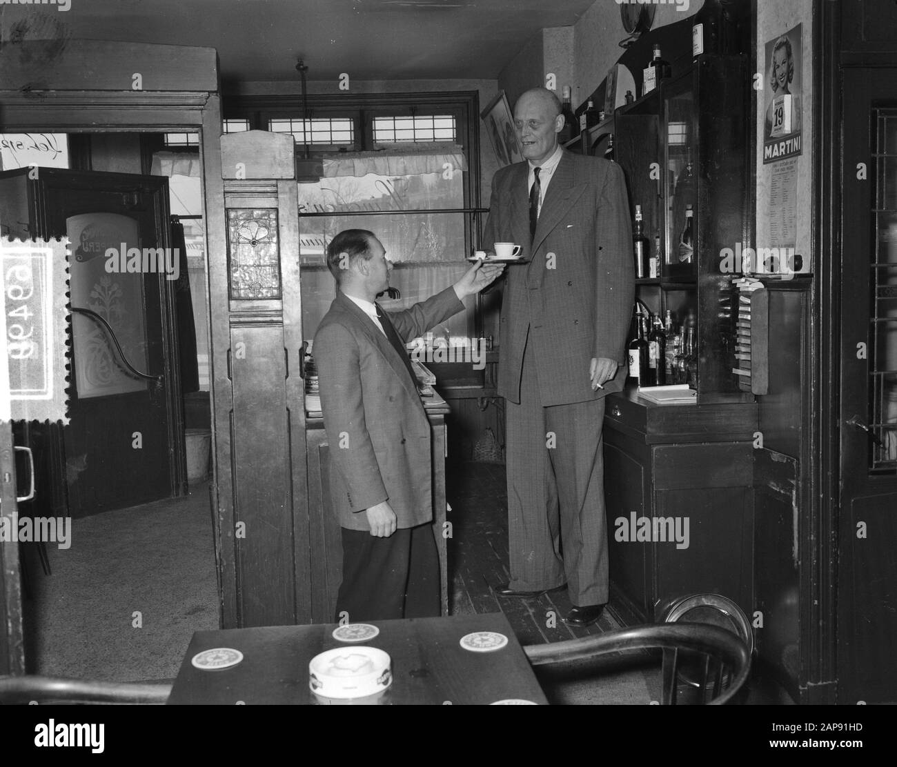 Albert J. Kramer, le plus grand homme au monde (2,42 m) dans son café à l'angle de Sloterkade et Theophile de Bockstraat à Amsterdam [a quitté son beau-frère] Date: 20 janvier 1955 lieu: Amsterdam, Noord-Holland mots clés: Cafés, restauration, hauteur, hommes Nom personnel: Kramer, A.J. Banque D'Images