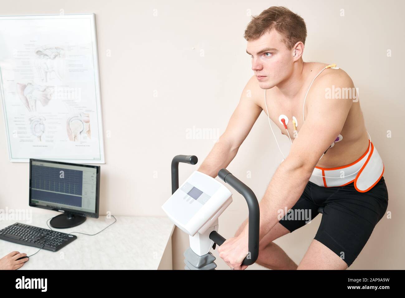 Homme patient, pédaler sur un système de test de stress ergomètre de vélo pour la fonction de coeur vérifiée. L'athlète effectue un test de stress cardiaque dans un médecin Banque D'Images