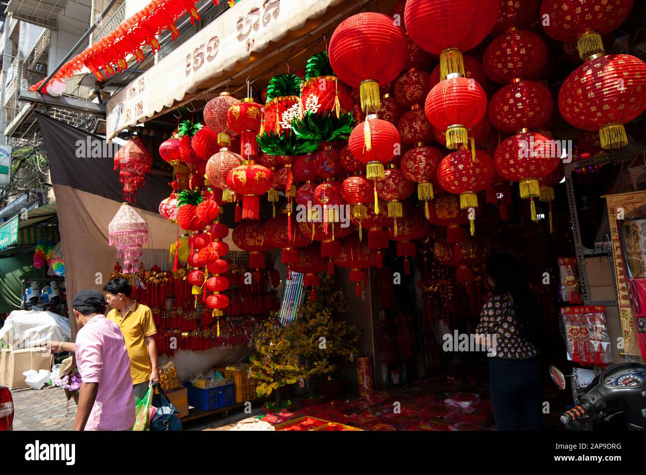 Lampions rouges sont suspendus au-dessus d'un trottoir à un magasin avant le Nouvel An chinois sur une rue de ville de Phnom Penh, Cambodge. Banque D'Images