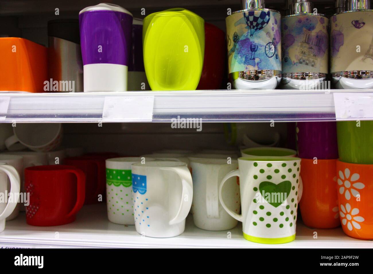 verres ou récipients colorés de divers articles ménagers pour tout usage domestique placés sur une étagère dans un magasin ou une étagère dans la maison en italie Banque D'Images