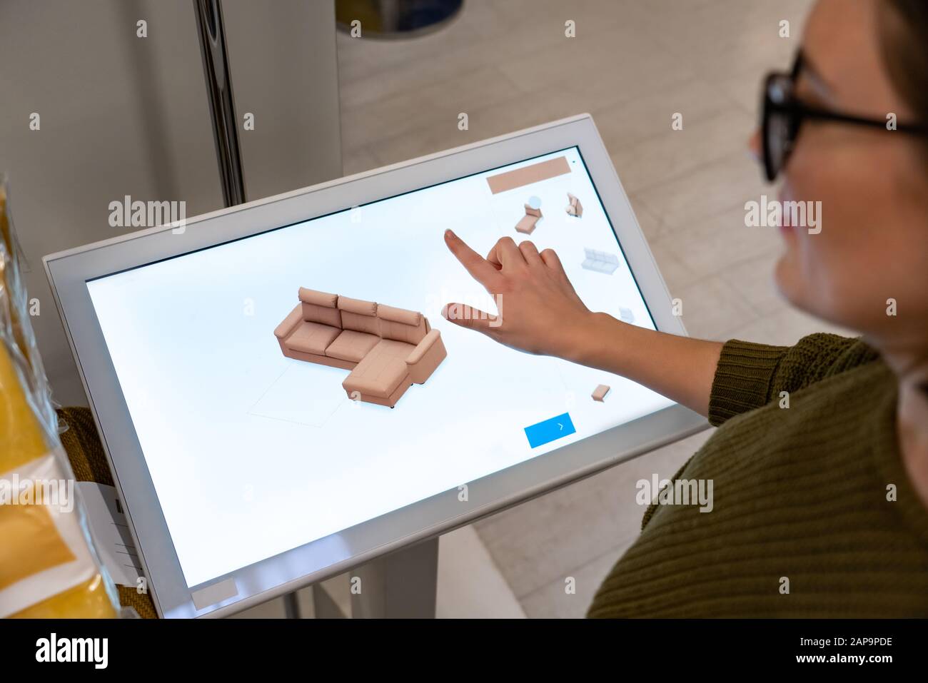 Une femme avec téléphone utilise un kiosque en libre-service dans le centre commercial Banque D'Images