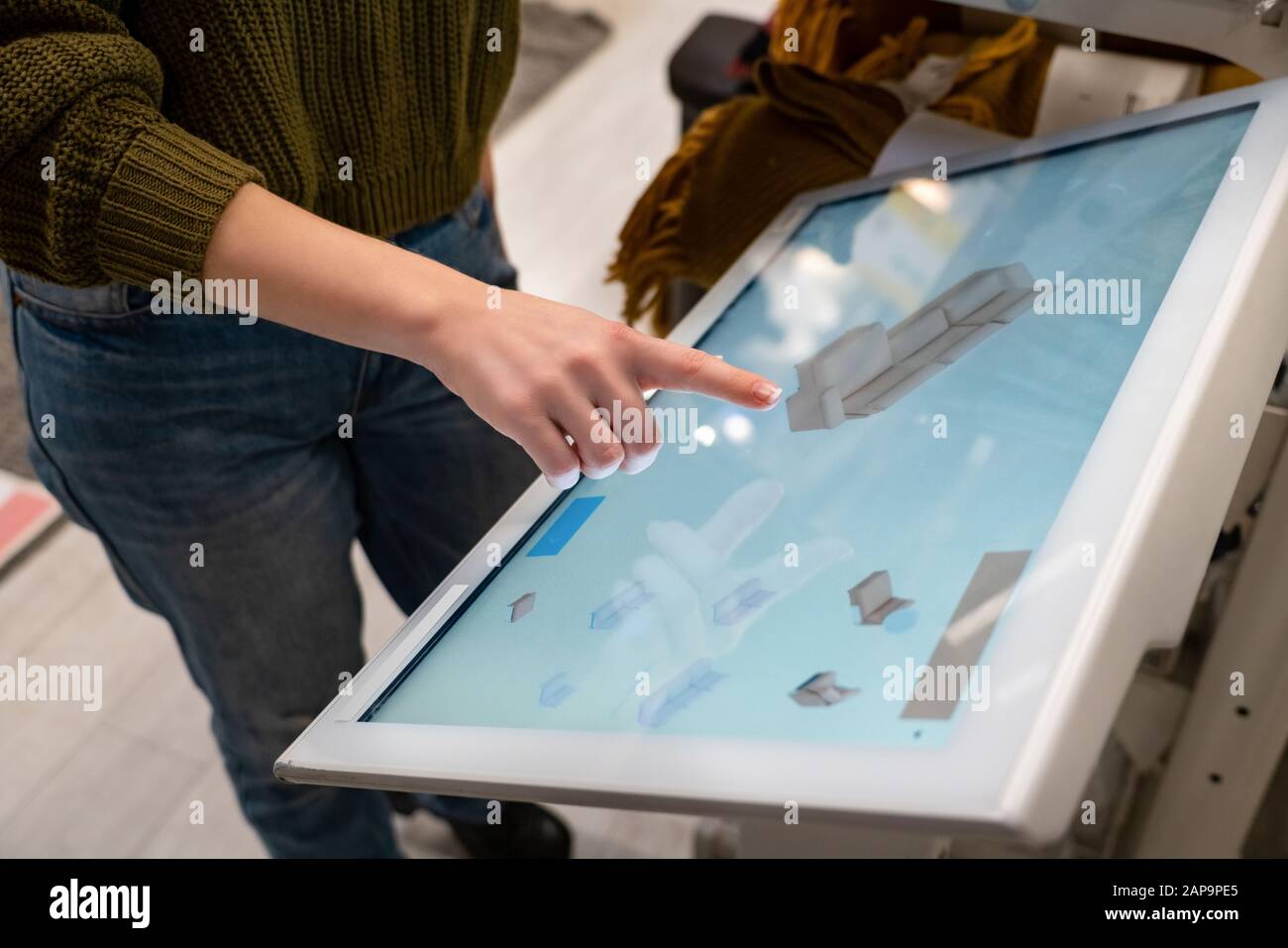 Une femme avec téléphone utilise un kiosque en libre-service dans le centre commercial Banque D'Images