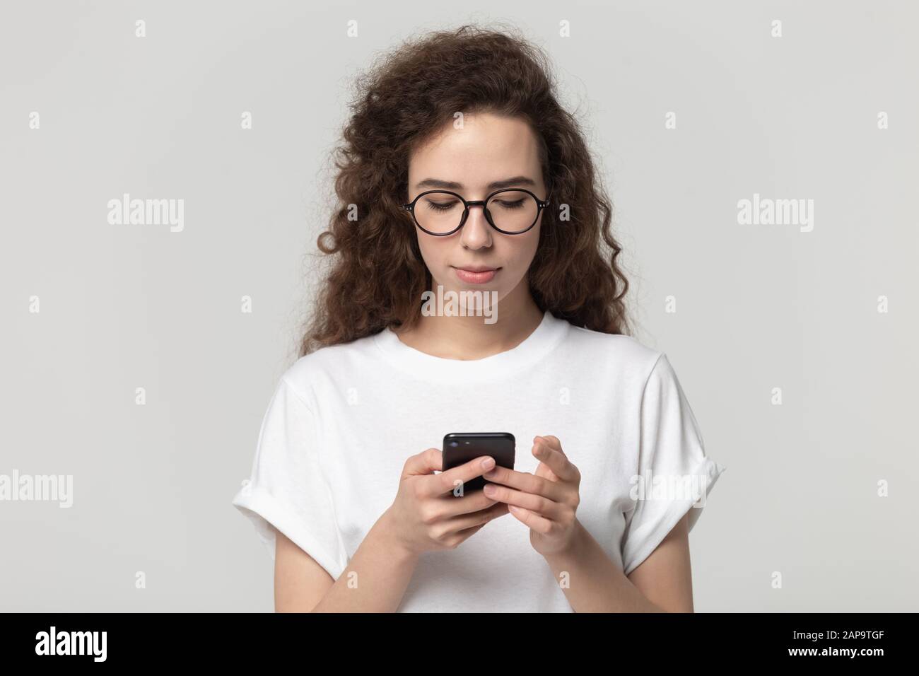Studio photo portrait isolé jeune femme tenant smartphone. Banque D'Images